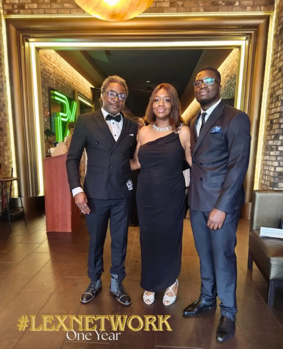 Three elegantly dressed individuals posing indoors beside a mirror.