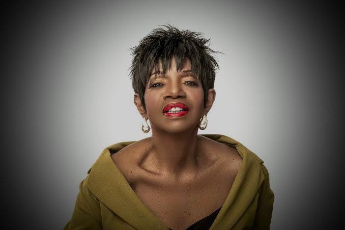 Confident woman with a stylish short haircut and bold red lipstick.